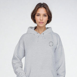 Person wearing a gray hoodie on a plain background