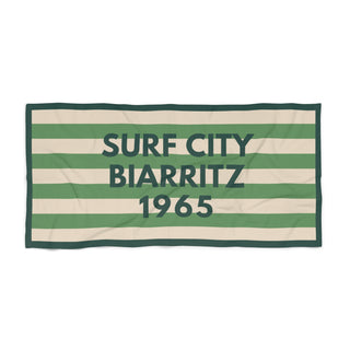 Striped towel with 'Surf City Biarritz 1965' text on a white background
