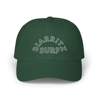 Green cap with 'BIARRITZ SURF' text on a white background