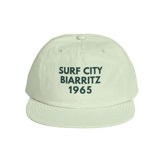 Light green cap with 'Surf City Biarritz 1965' text on a white background