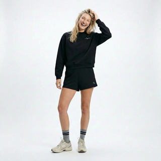 Person wearing a black sweatshirt and shorts set on a white background