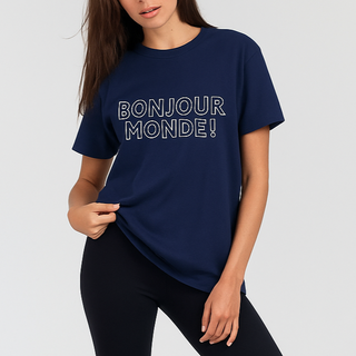 Woman wearing a navy blue t-shirt with 'Bonjour Monde!' text, black leggings, and white sneakers on a white background.