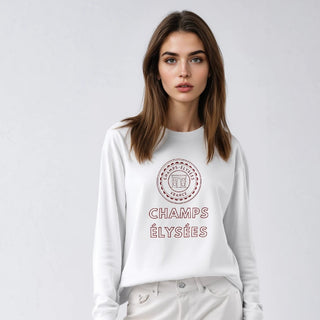 Woman wearing a white sweatshirt with text and light-colored pants on a plain background