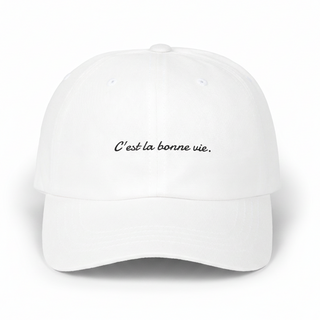 White cap with 'C'est la bonne vie' text on a white background