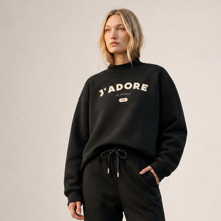 Person wearing a black 'J'Adore' sweatshirt and pants on a plain background