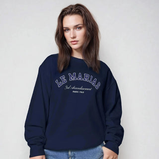 Person wearing a navy blue sweatshirt with text on a plain background