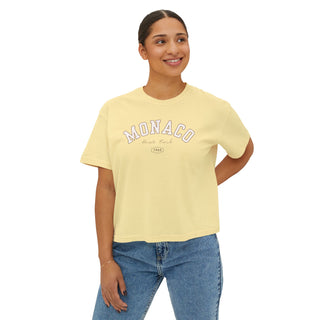 Woman wearing a yellow t-shirt with 'Monaco' print on a white background