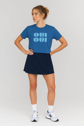 Woman wearing a blue t-shirt with 'OU! OU!' text and a black skirt on a light gray background
