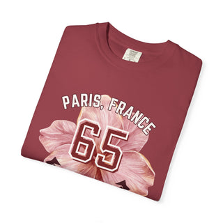 Folded maroon t-shirt with 'Paris, France 65' text and floral design on a white background