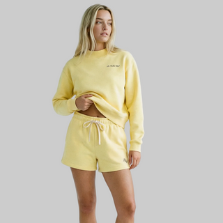 Woman wearing a yellow outfit with a plain background